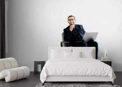 Pleasant positive business man using laptop on white background Wall mural